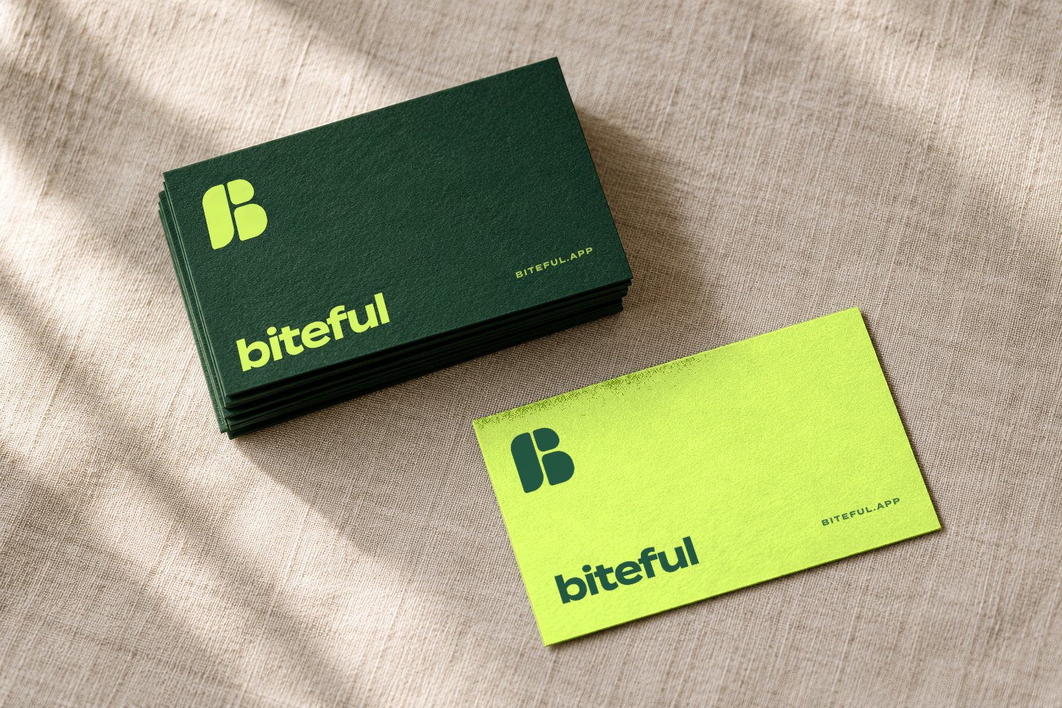 Forest green business cards with the lime mark and wordmark